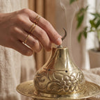 Copper incense burner lid close-up with engraved floral design and small holes