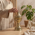 Copper incense burner with lid; visible smoke and top held over base tray
