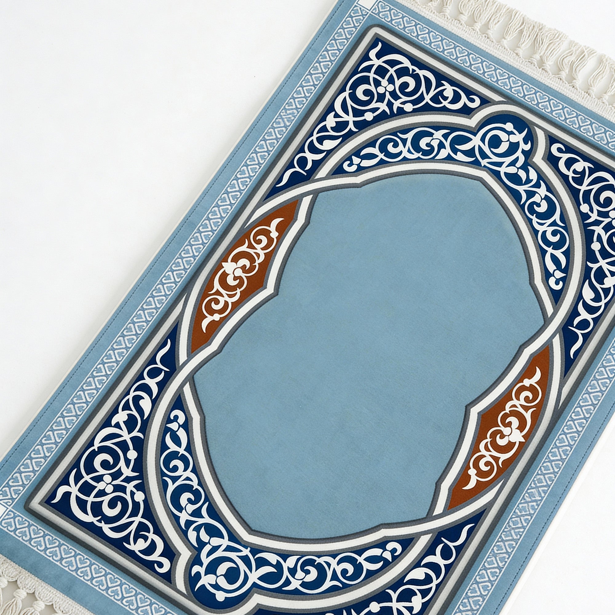Prayer mat in light blue with white and navy arch pattern, tassels along the border