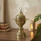 Copper incense burner with smoke drifting upward from the lid opening
