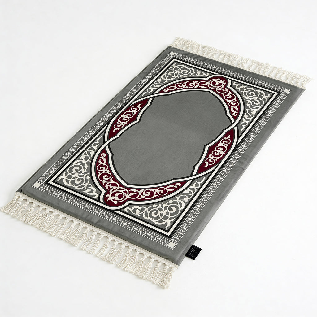 Padded prayer mat in dark grey with red and white arch pattern, tasseled edges
