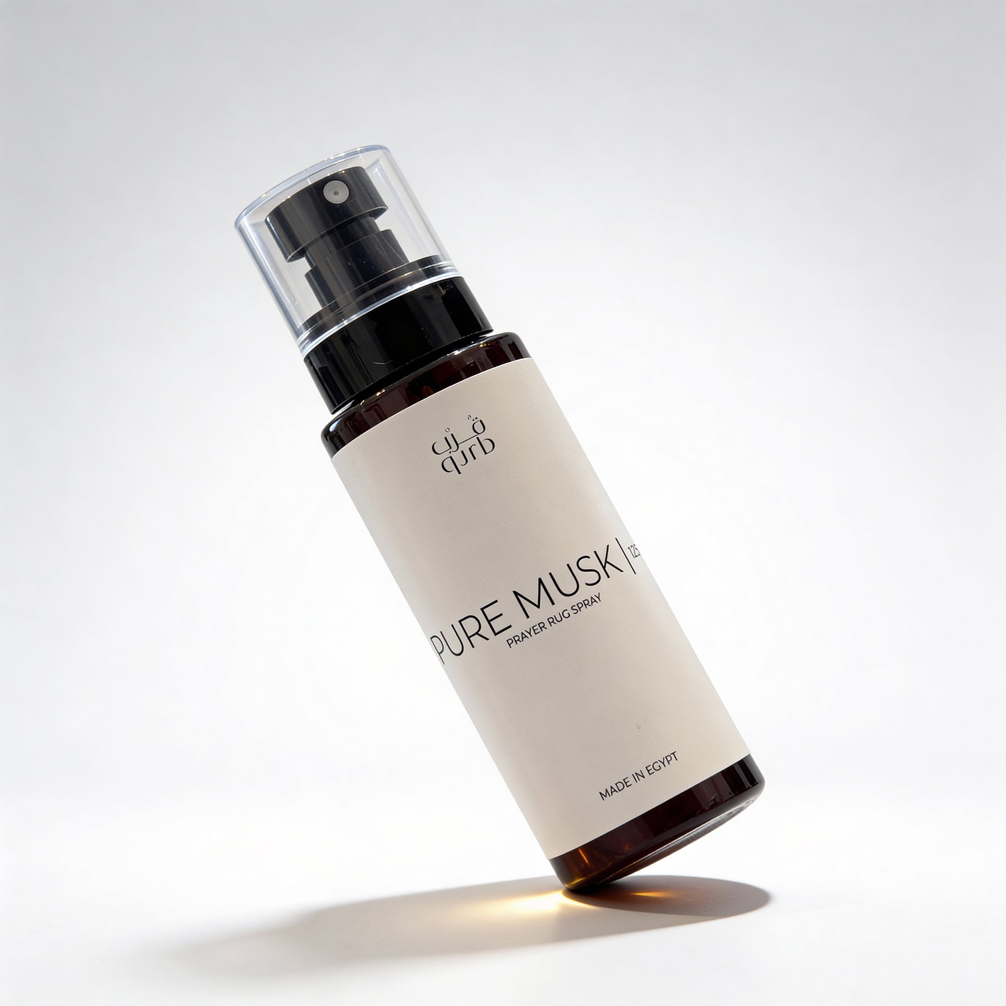 Bottle of 'Pure Musk' perfume spray on a light gray background