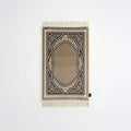 Padded prayer mat with beige border, dark arch medallion, and white fringe tassels
