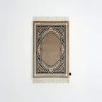 Padded prayer mat with beige border, dark arch medallion, and white fringe tassels