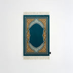 Padded prayer mat with teal border, dark blue arch medallion, and white fringe tassels