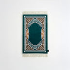 Padded prayer mat with dark teal border, teal arch medallion, and white fringe tassels