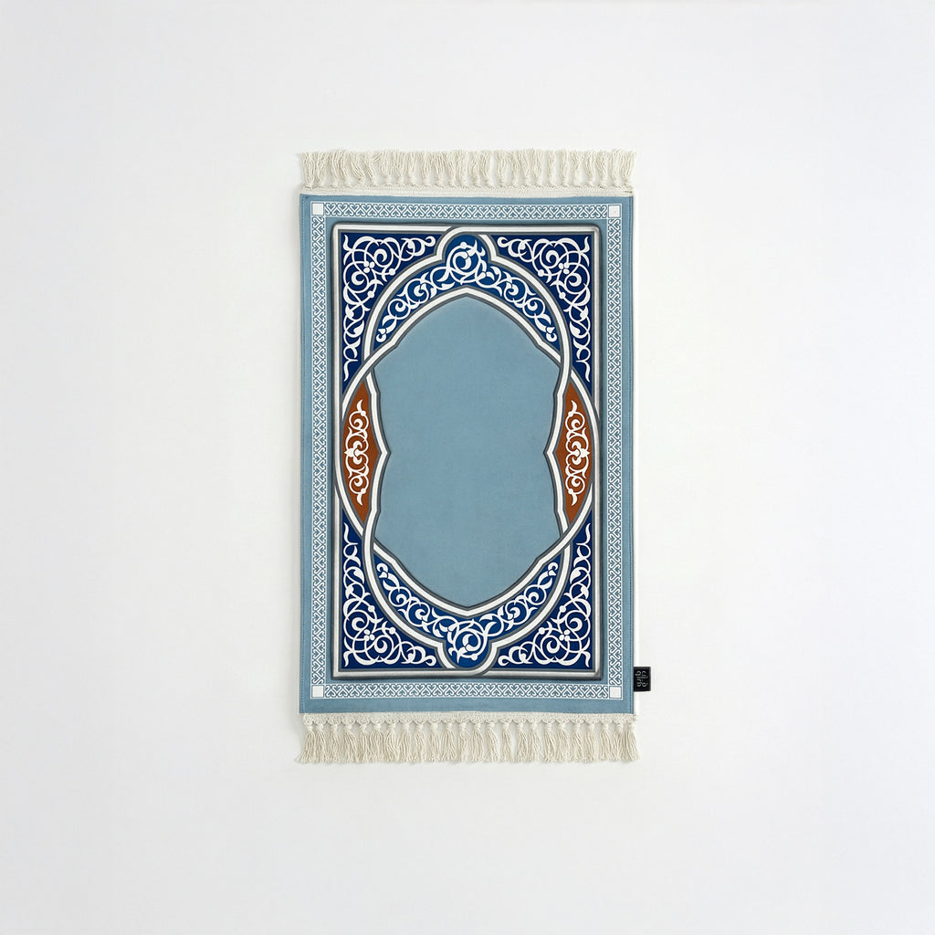 Padded prayer mat with blue border, blue arch medallion, and white fringe tassels