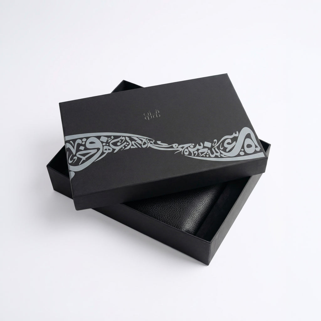 Black gift box with decorative band and black leather-style insert