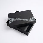 Black gift box with decorative band and black leather-style insert