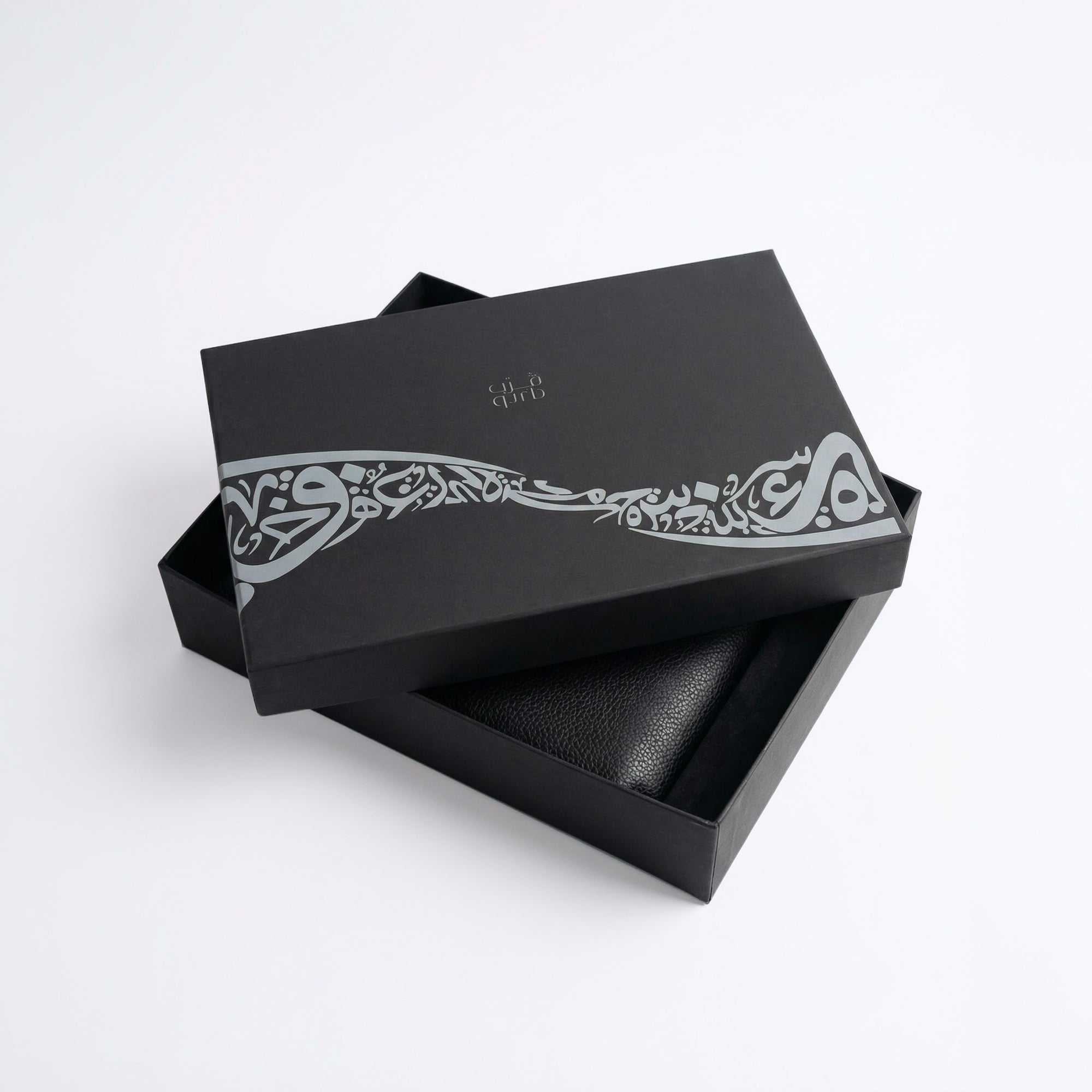 Black gift box with decorative band and black leather-style insert