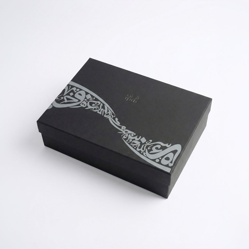 Black gift box with white decorative calligraphy band on the lid