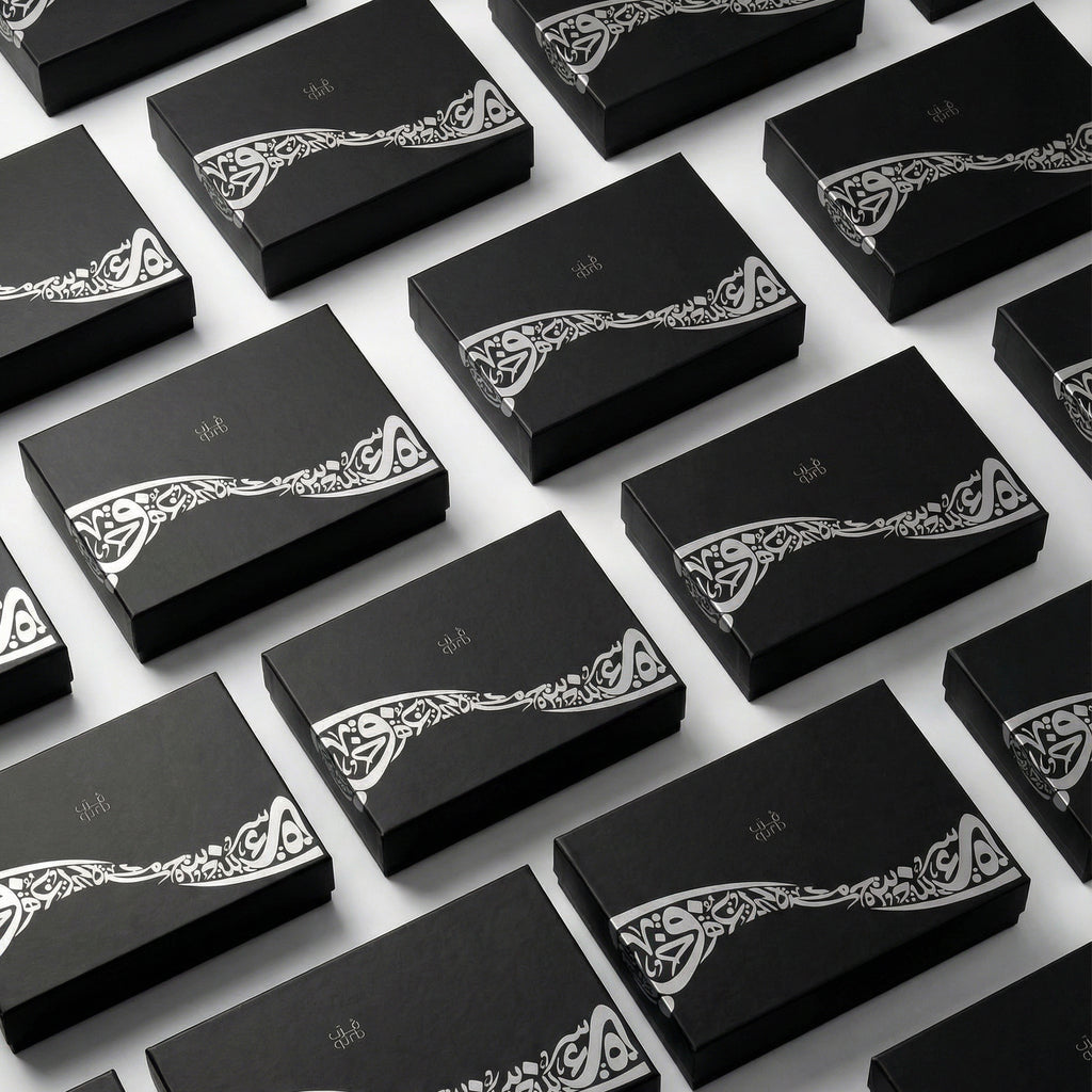 Multiple black gift boxes with white decorative calligraphy on the lids
