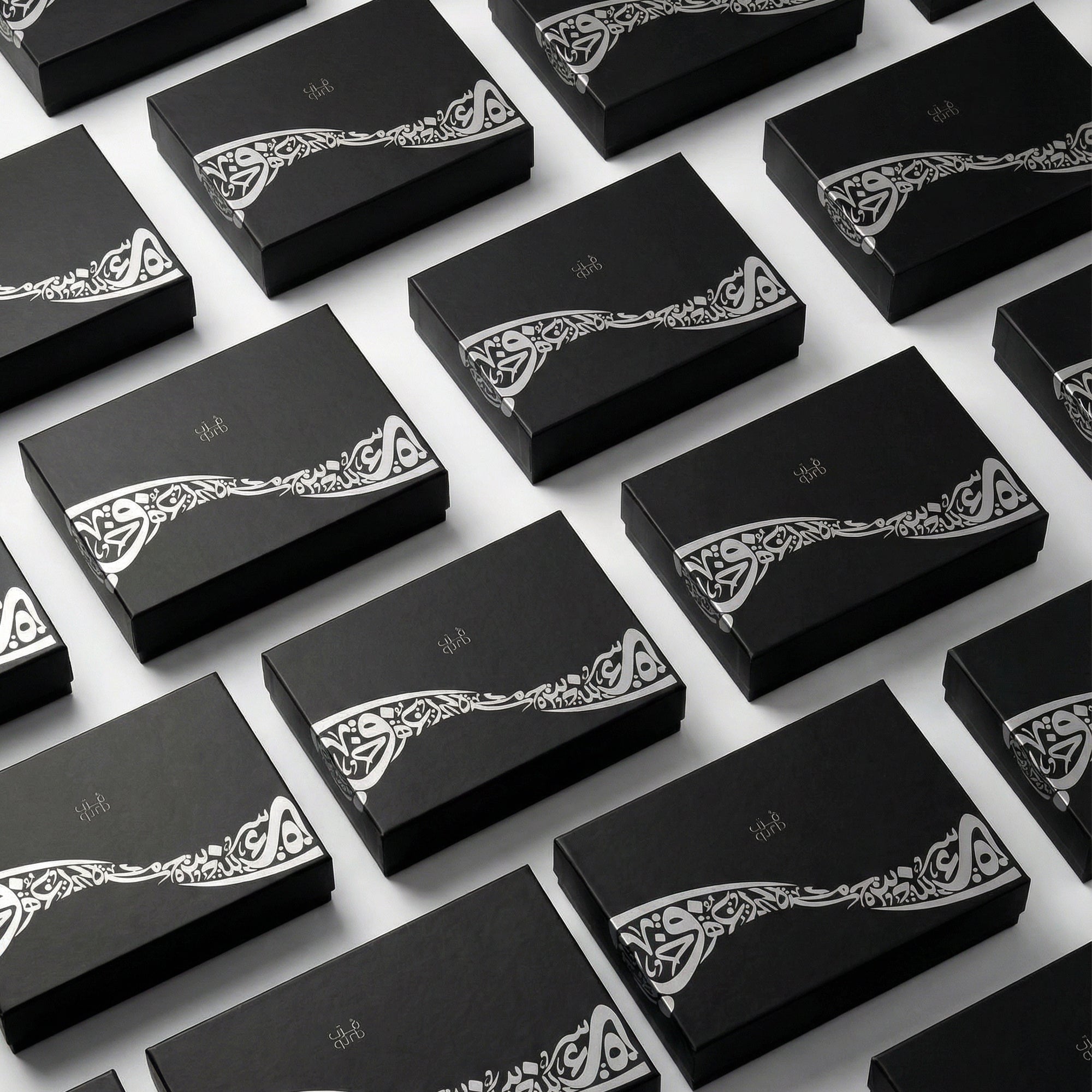Multiple black gift boxes with white decorative calligraphy on the lids