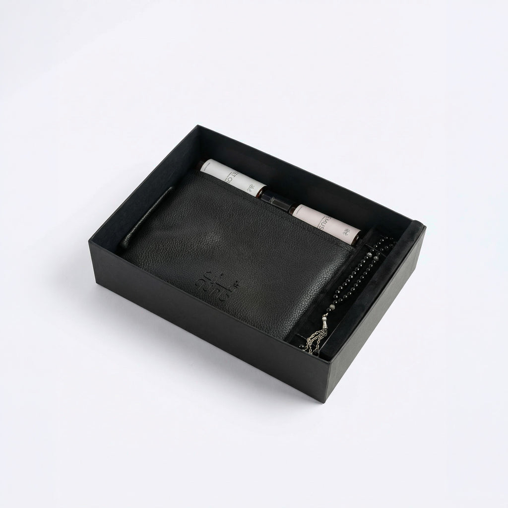 Black leather-style organizer box with rolled spray bottles and beaded bracelet
