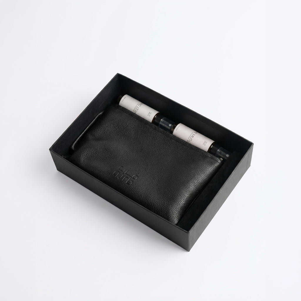 Black leather-style organizer box with two spray bottles and beaded bracelet