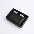 Black leather-style organizer box with two spray bottles and beaded bracelet